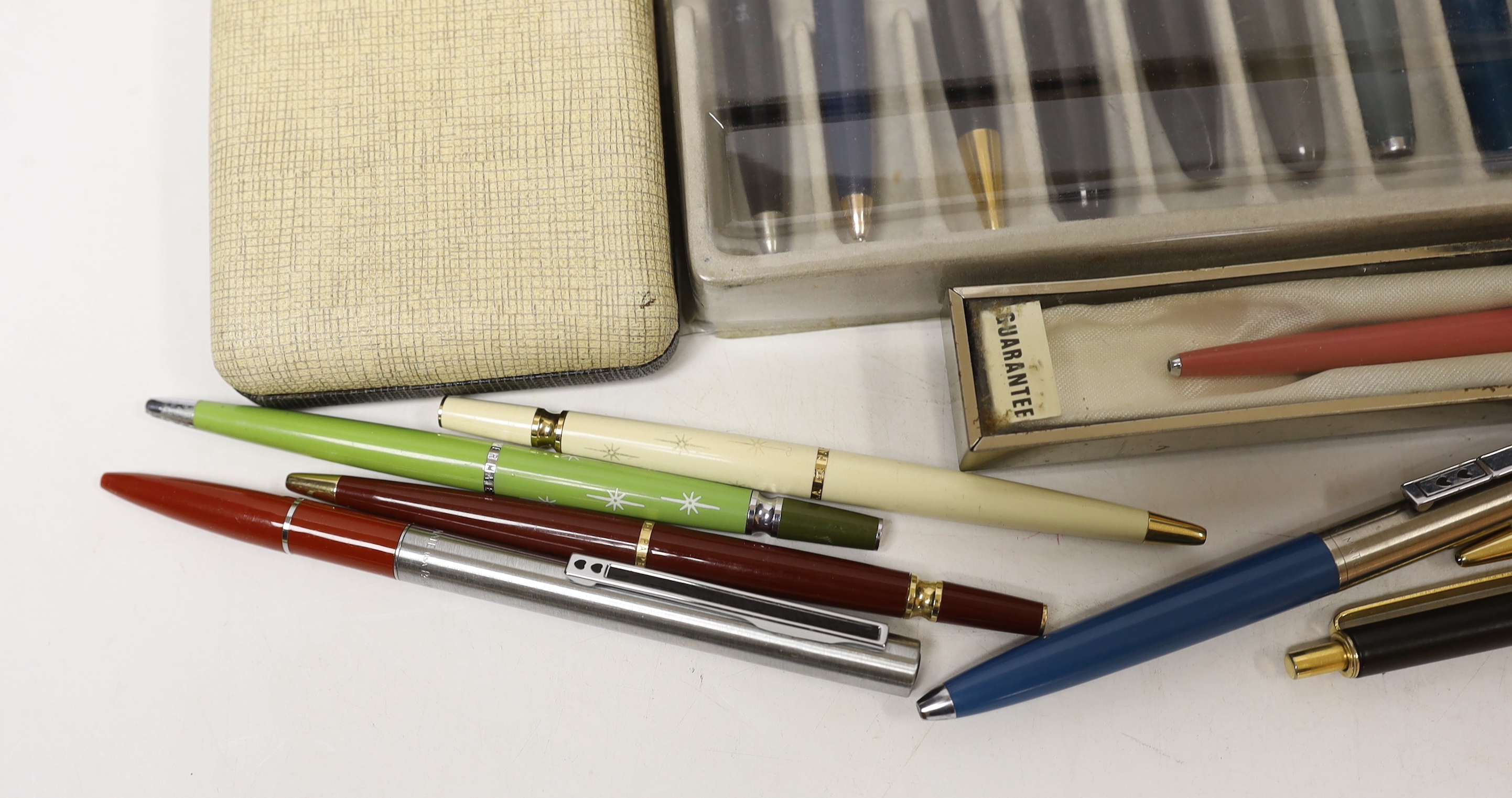 A collection of pens including Parker and pen-related publications